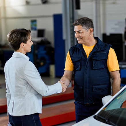 customer shaking hands with an auto repairman